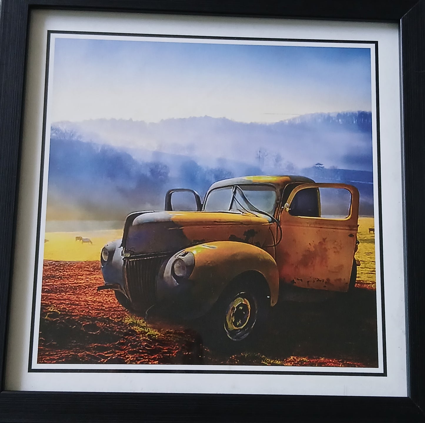 Framed photograph of an old rusted truck in a field with a mountainous background