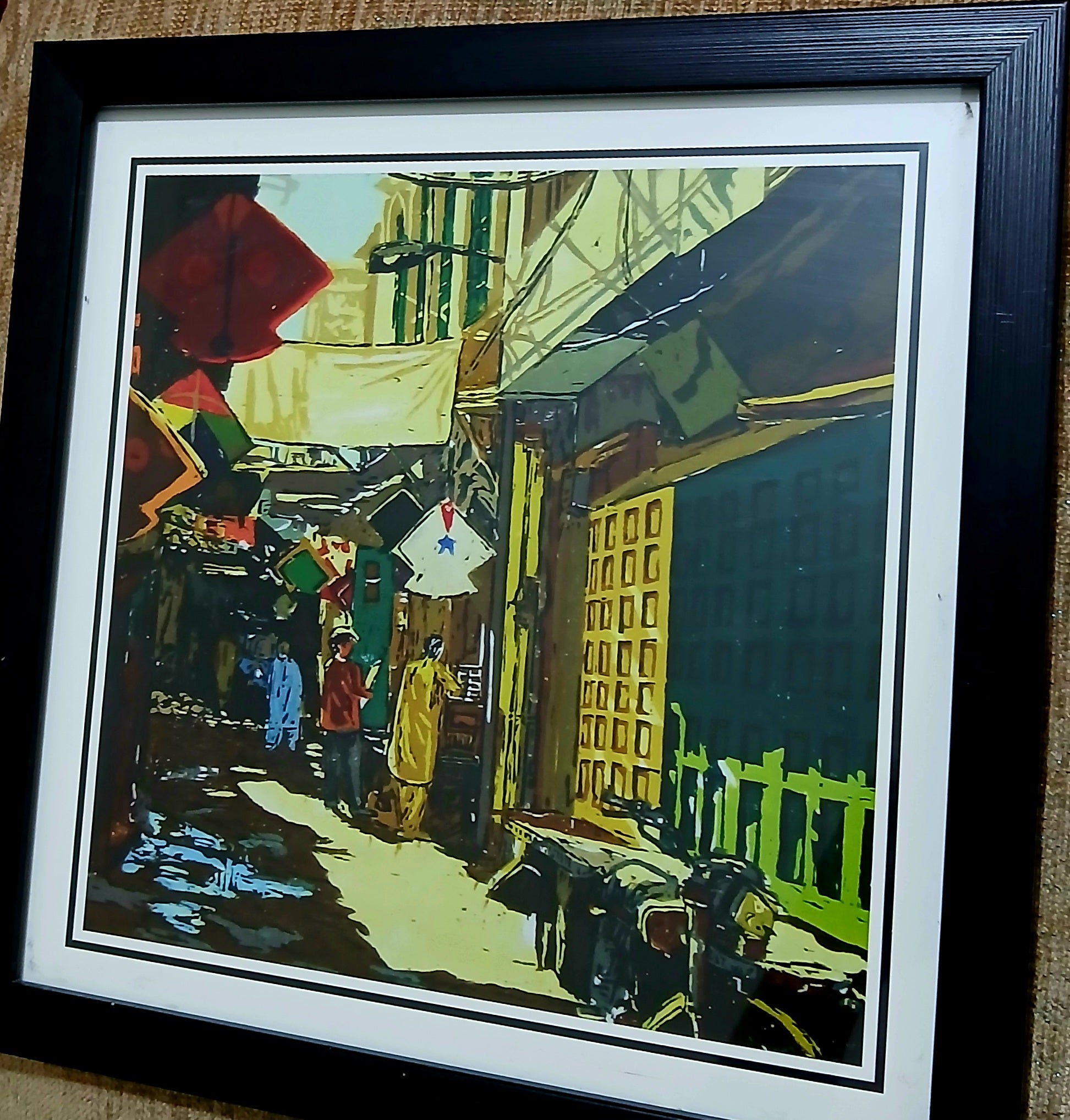 Framed photo print of colorful old Pakistani neighborhood with kite, man, and bike. Compact 8.5 x 8.5 inch wall art in wooden frame.
