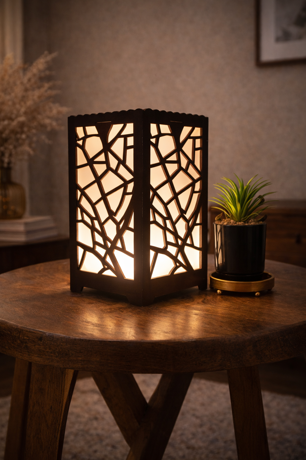 Decorative lamp with intricate cut-out design on a wooden table.